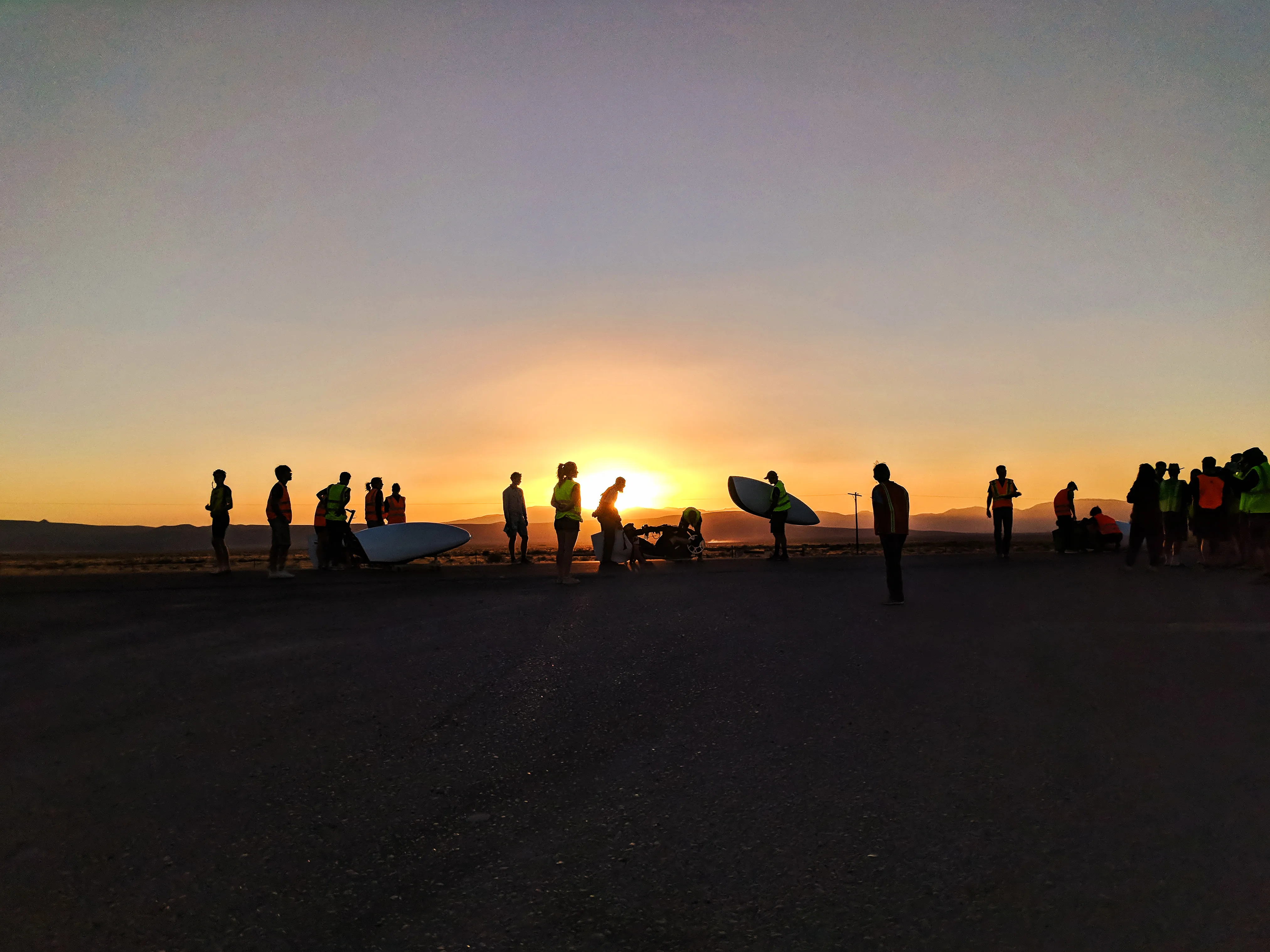 Team silhouetted against the sunset before a land speed run in Nevada