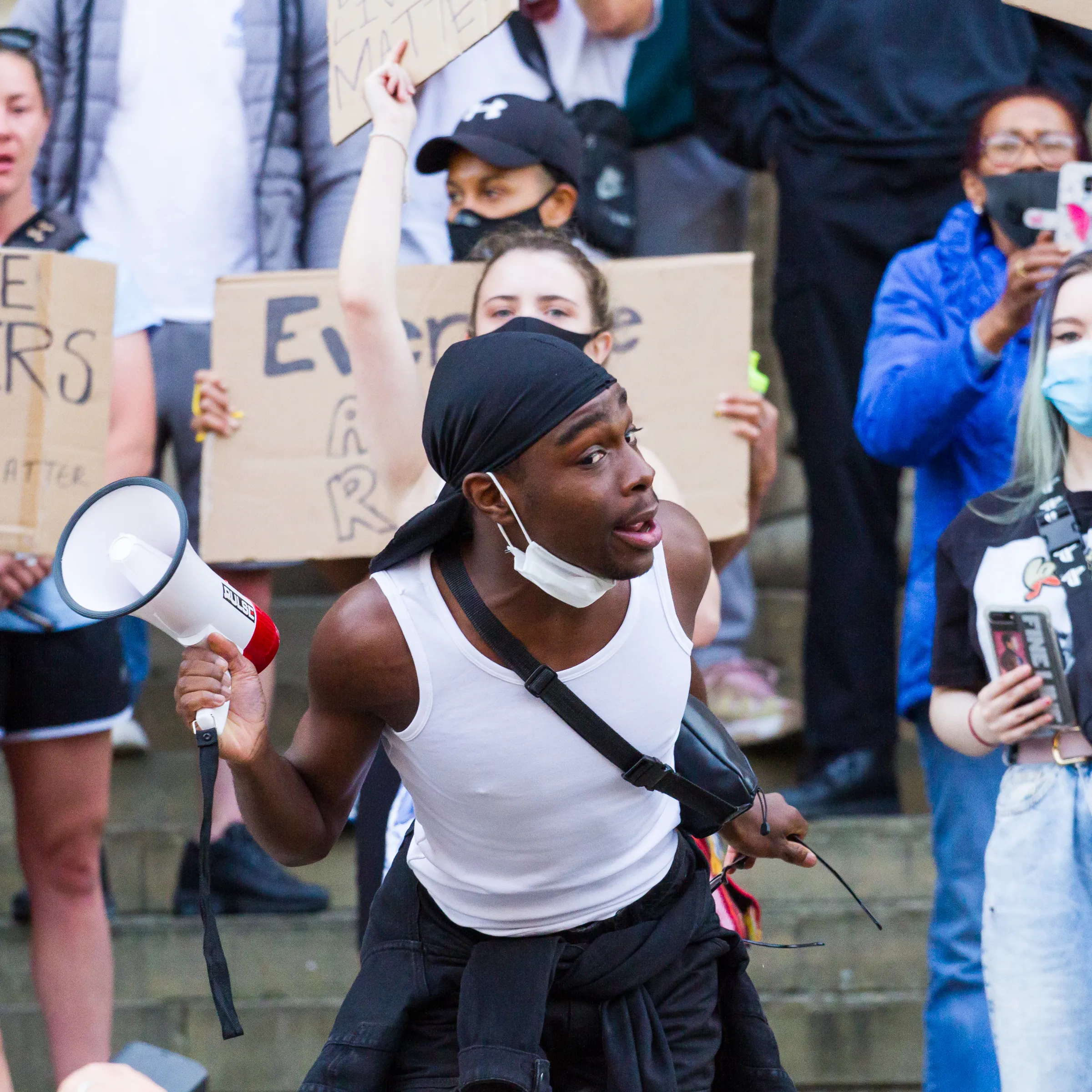 A man mid-shout into a megaphone at a Black Lives Matter protest