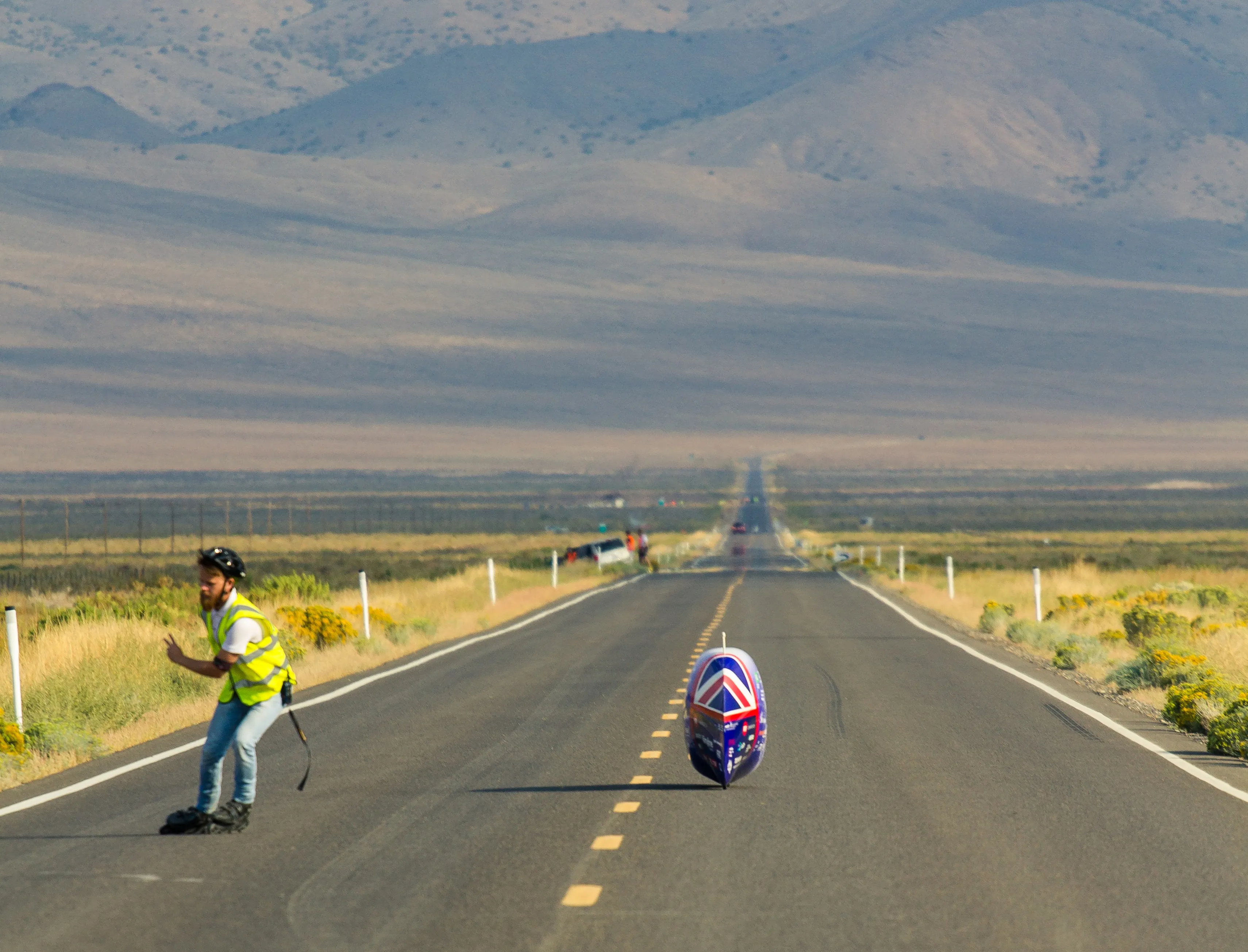 ARION1 alone on a long straight desert road, mountains in the distance